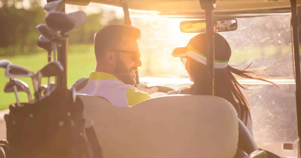 Man and woman in golf cart.
