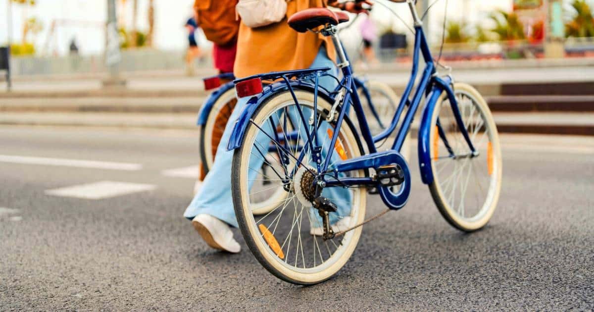 Stylish couple walking with bikes on a city street. Salt Lake City is a great place for a date.