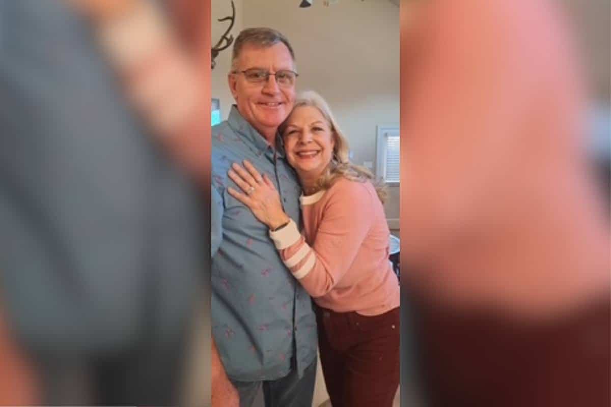 Brian and Nancy smiling together and embracing one another.