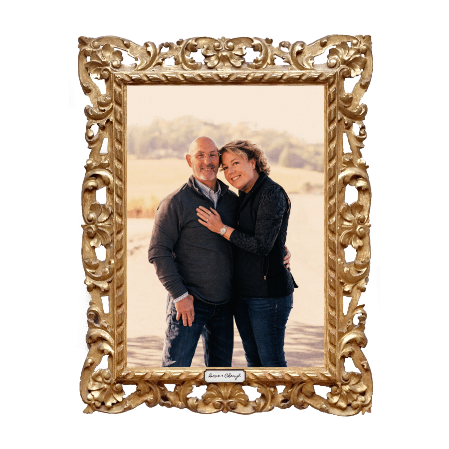 Partners hold each other as they smile for a photo
