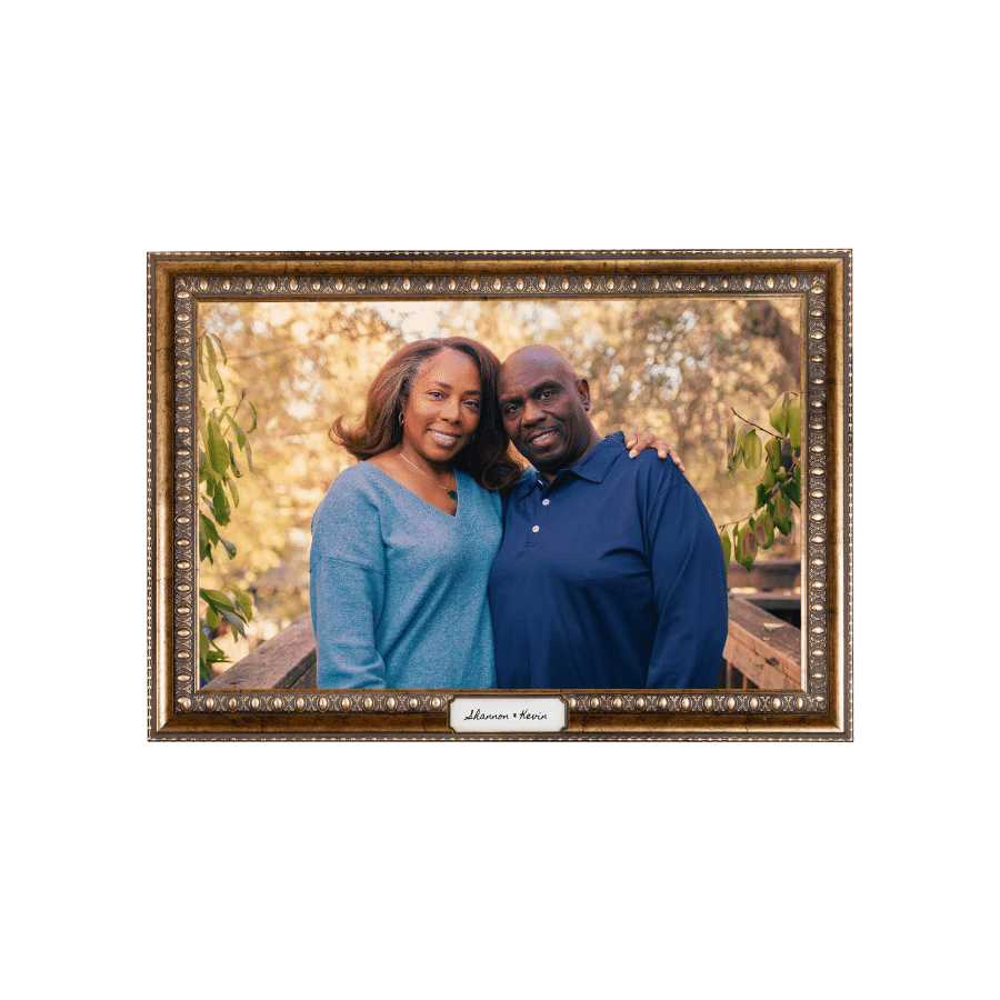 Couple grins and holds each other in a garden