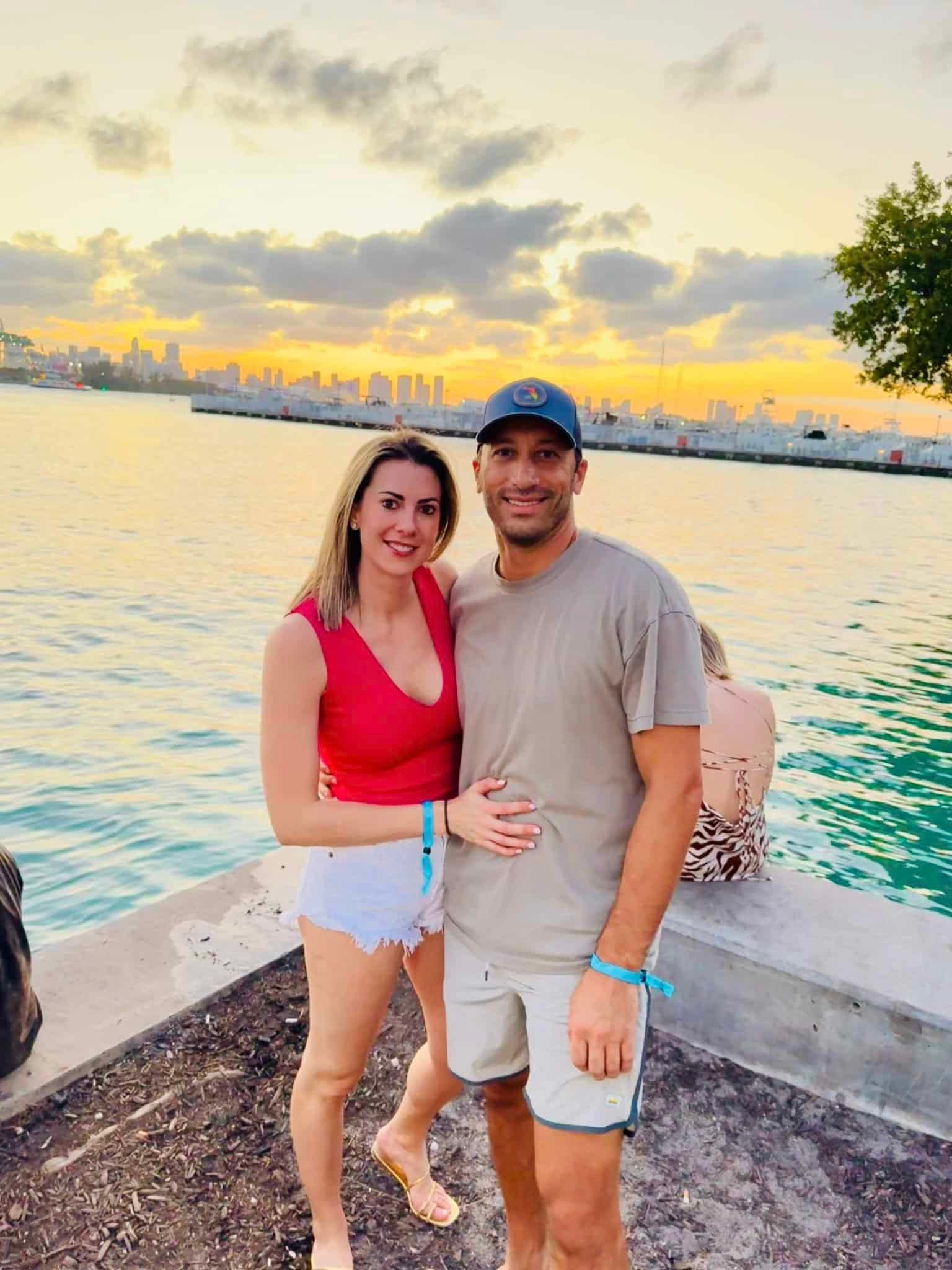 Frank and Niki posing contentedly together by the water at sunset.