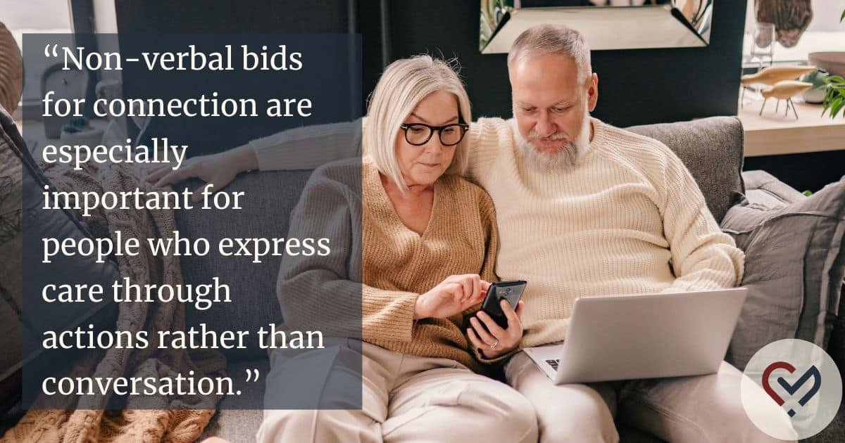 Happy couple sitting close together and smiling while looking at a phone, showing shared attention and emotional connection in a relationship